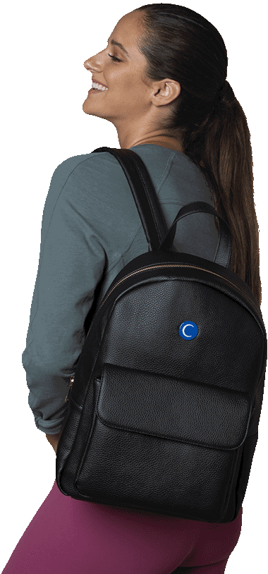 Una señora con una mochila de espaldas sonriendo.