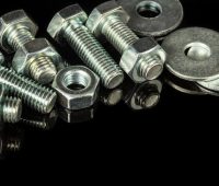 Imagen de tornillos plateados con fondo negro.